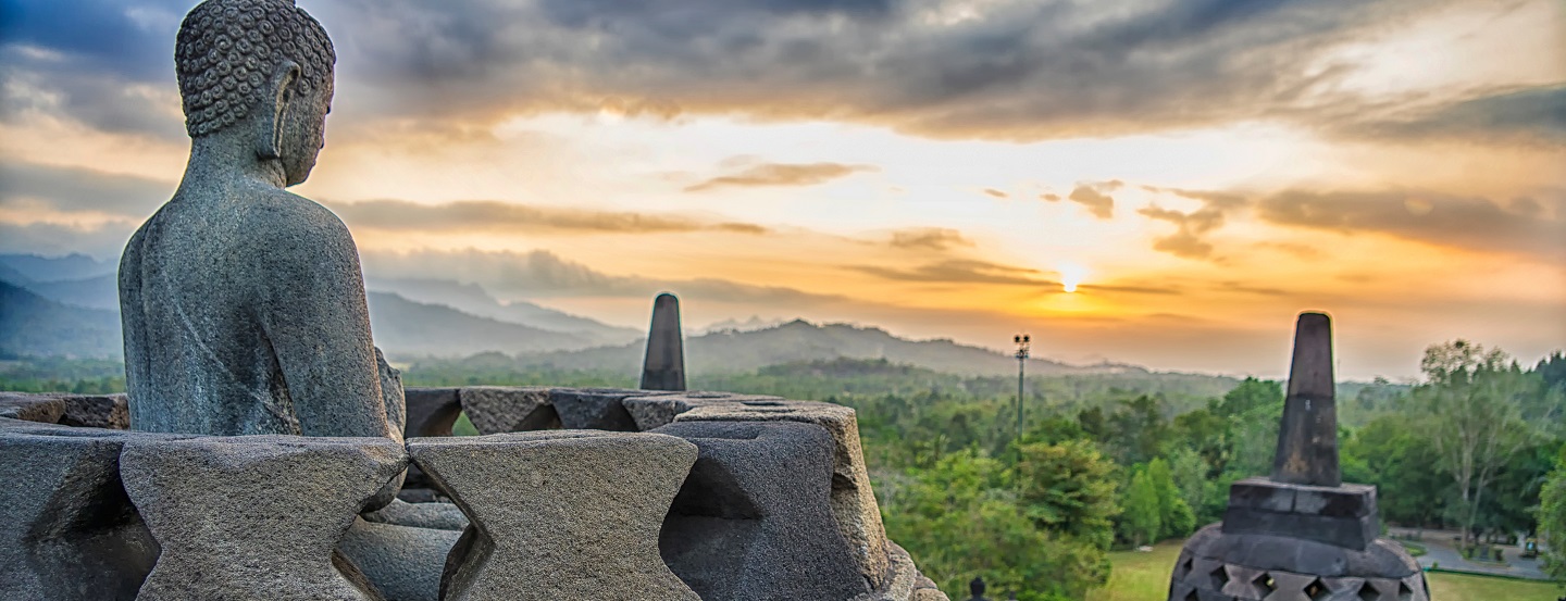 A sunset view of the ancient Borobudur temple complex in Central Java