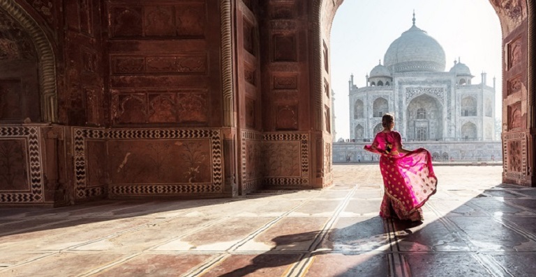 Sun falls on a woman wearing a beautiful pink sari.