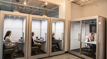 SnapCab’s modular, enclosed pods being used in an open workspace environment for privacy and noise reduction.