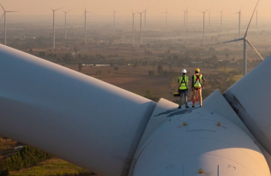 Deux techniciens debout sur une éolienne