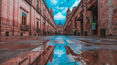 Cobblestone street leading to a domed church