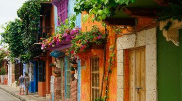 Couple walking down street of colourful buildings