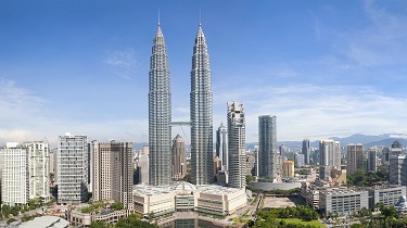 A panoramic cityscape of the downtown area of Malaysia’s capital city, Kuala Lumpur, including the Petronas Twin Towers and other skyscrapers.