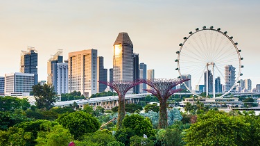 City view of Singapore’s OCBC Skyway and Gardens by the Bay with office towers in the background.