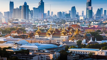 The Golden Grand Palace of Bangkok with skyscrapers in the background.