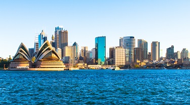 L’Opéra de Sydney avec la ligne d’horizon de la ville au coucher du soleil.