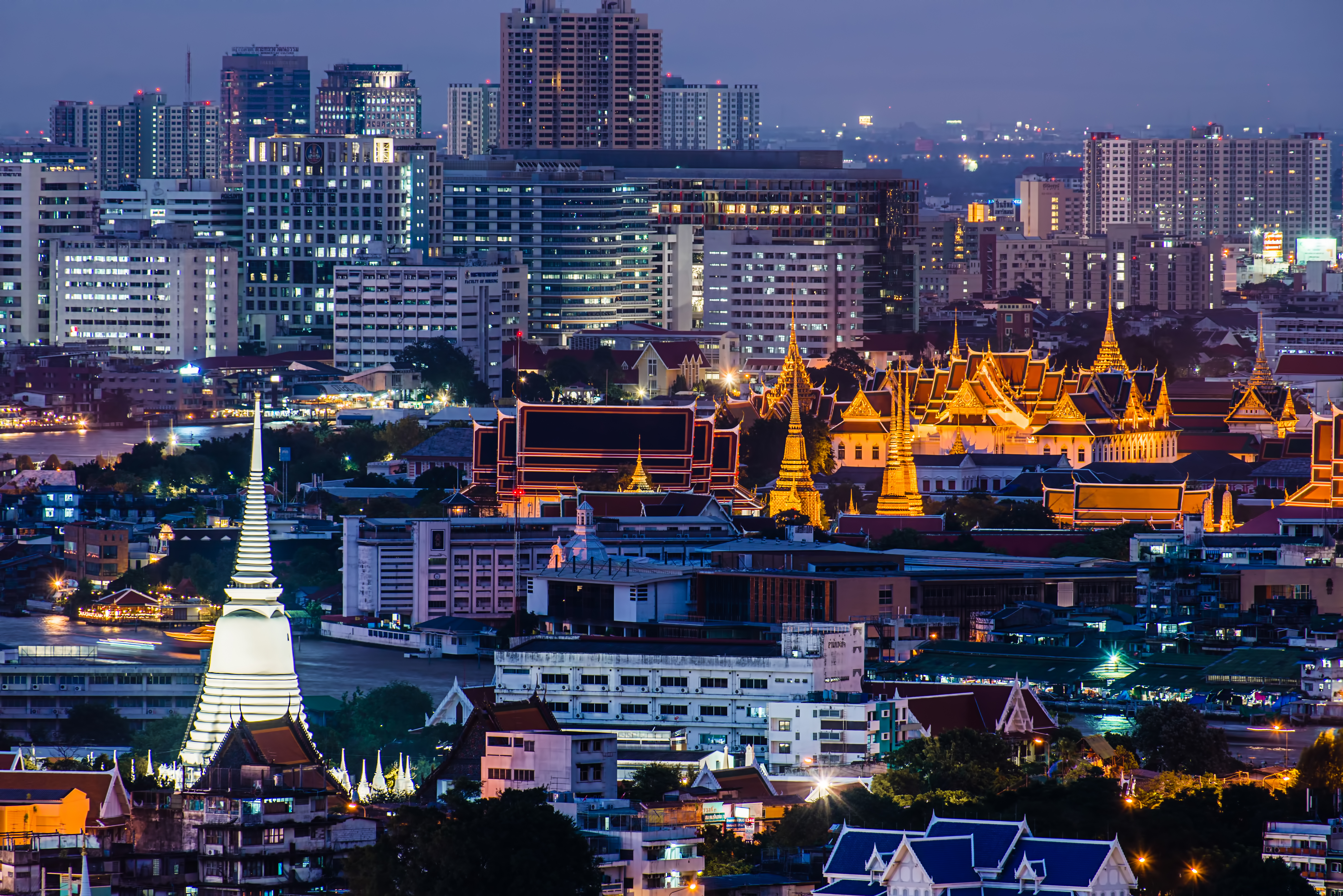 Bangkok skyline at night with palace against modern buildings