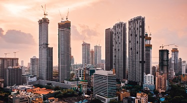 The skyline of Mumbai, India, at sunset. Many skyscrapers are under construction. 