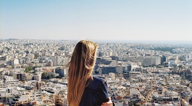 A woman entrepreneur gazes over a sprawling city.