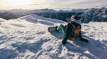 Une femme descend une montagne en planche à neige.