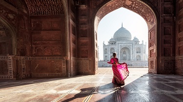 Sun falls on a woman wearing a beautiful pink sari.