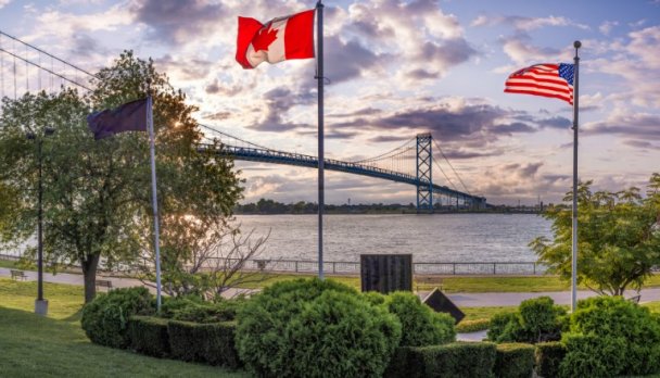 Canadian and U.S. flags at the Ambassador Bridge, a key cross border trade corridor.