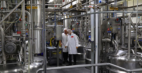 Two BCI Foods employees examine the factory’s sophisticated equipment.