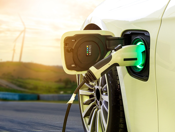 An electric car plugged in at the charging station.