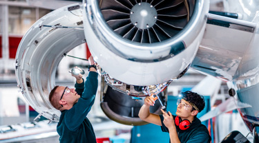 Deux ingénieurs de maintenance inspectent un moteur d’avion dans un hangar d’entretien.