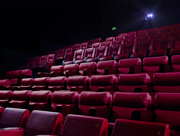 Des rangées de sièges rouges vides à l'intérieur d'une salle de cinéma.