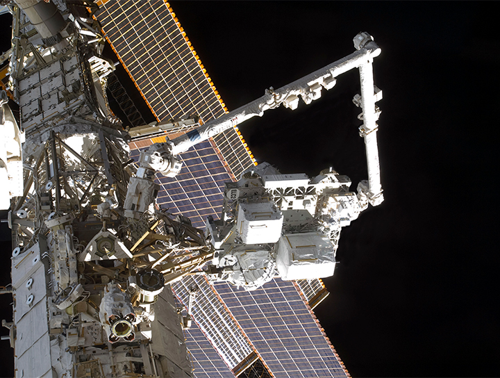 Le système de manipulateur à distance de la station spatiale (Canadarm), de fabrication canadienne, qui s'étend depuis la station spatiale.