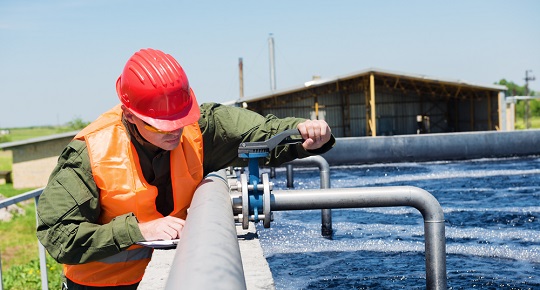 A worker checks pipes at a water treatment plant.
