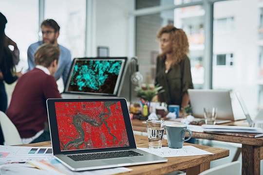 Laptop on desk showing a bright red map