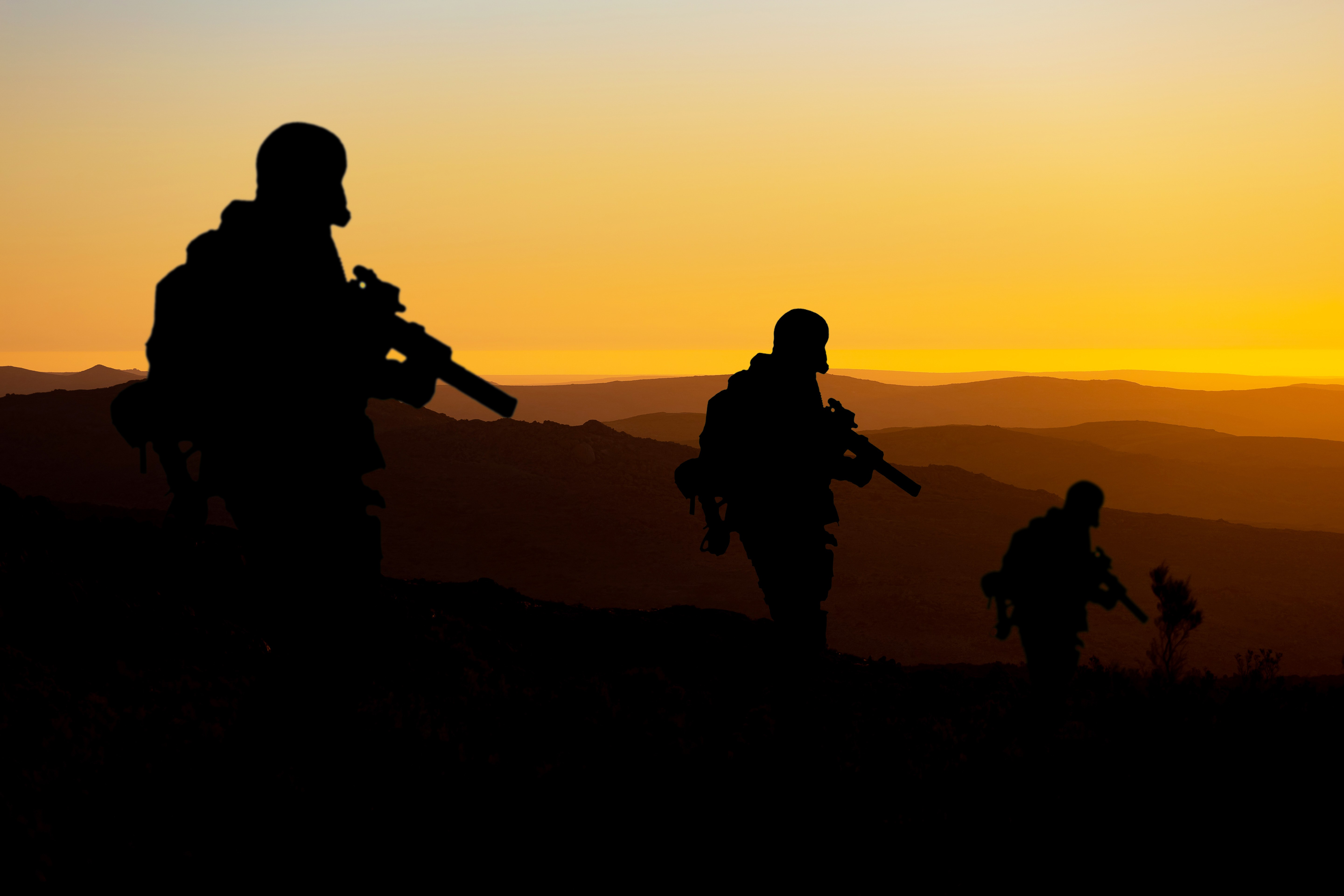 Silhouette de soldats au coucher du soleil symbolisant la guerre et les tensions géopolitiques