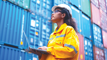 An engineer inspects shipping containers, illustrating global trade and export strategy.