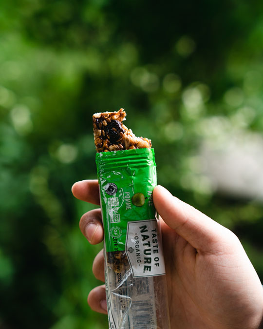 Une personne mange une barre granola.