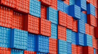 Empilement de conteneurs d’expédition bleus et rouges dans un terminal.