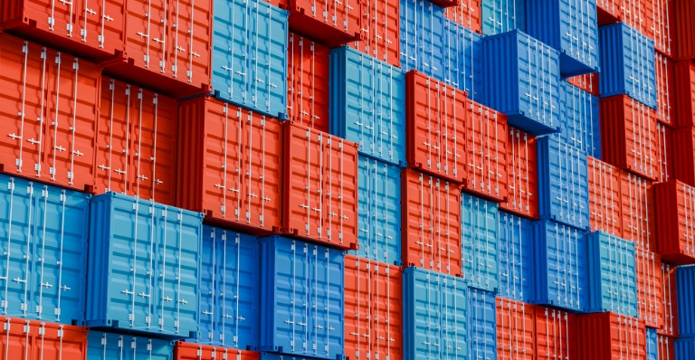 Empilement de conteneurs d’expédition bleus et rouges dans un terminal.