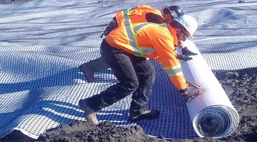 Travailleurs installant un matériau au sol