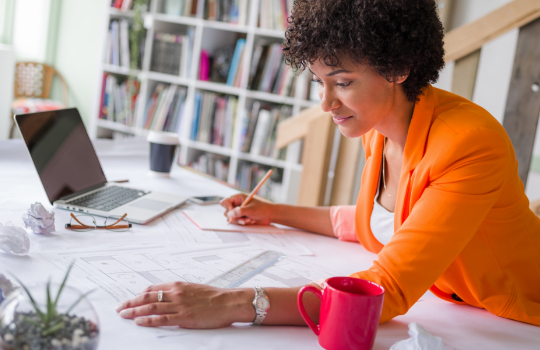 Female architect at her desk drafting plans