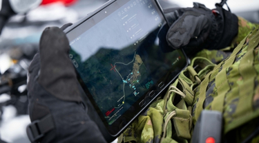 Canadian military personnel using a tablet during a winter defence training exercise in the Arctic.