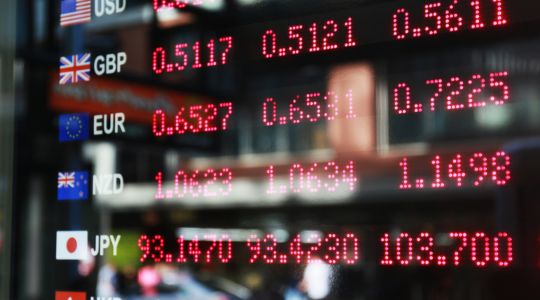 Tableau d'affichage numérique des taux de change actuels pour plusieurs devises internationales, notamment l'USD, la GBP, l'EUR, le NZD, le JPY et le HKD.
