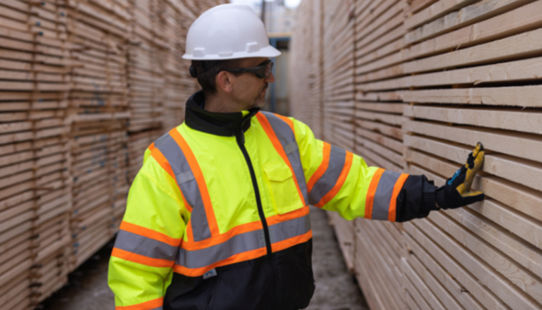 Al Balisky, président et chef de la direction de Meadow Lake Tribal Industrial Investments, inspecte des piles de produits de bois finis.