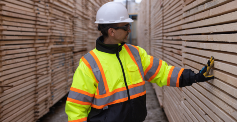 Al Balisky, president and CEO of Meadow Lake Tribal Industrial Investments, inspects stacks of finished lumber products.