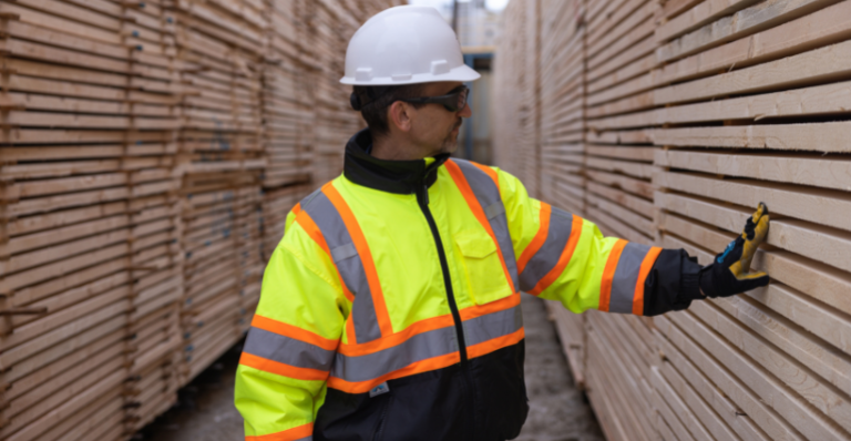 Al Balisky, président et chef de la direction de Meadow Lake Tribal Industrial Investments, inspecte des piles de produits de bois finis.