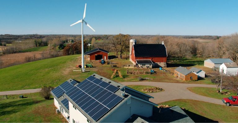 Eocycle’s high-performance wind turbine stands on a rural farm, where solar panels are installed on the farmhouse roof.