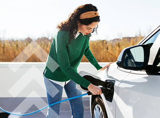 A woman connecting a charger to an electric vehicle.