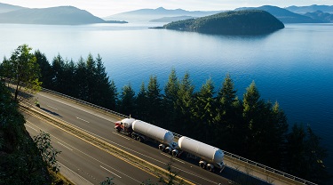 18-wheeler truck driving on road with picturesque scenery