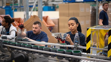 Factory worker checks quality of manufactured part.