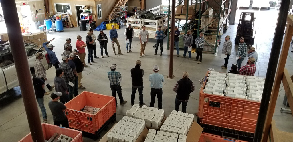 Management and workers gathered in the warehouse