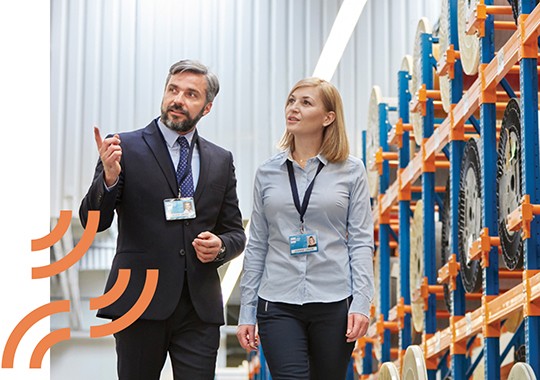 Businessman and businesswoman touring a fibre optic factory