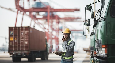 Dans un port, des travailleurs communiquent avec des walkies-talkies.  