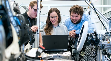 Three engineers working on new software for a car