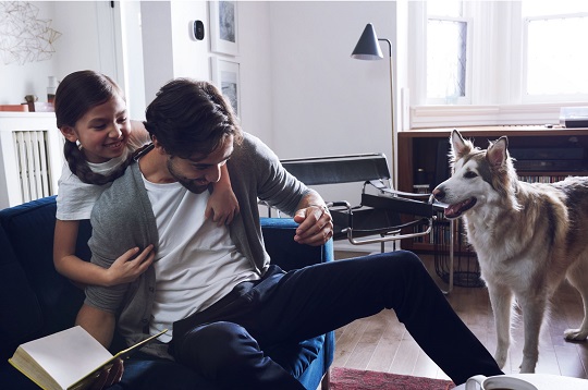 Father and daughter sitting in living room having fun