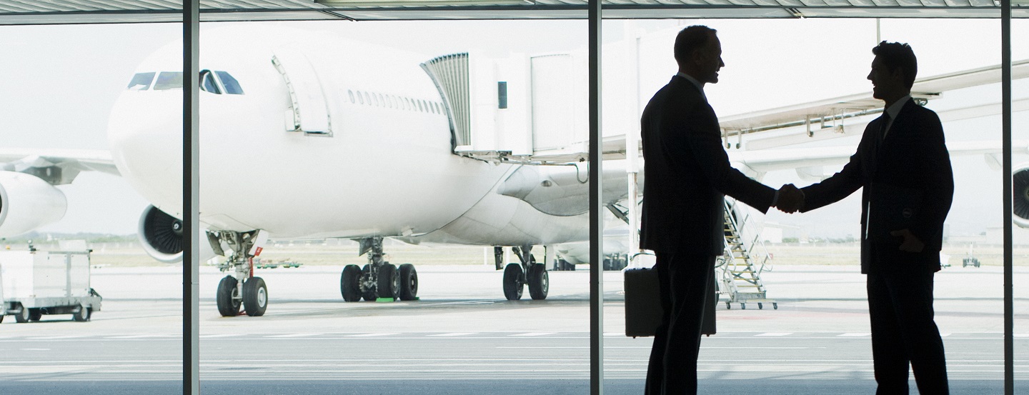 Des hommes d’affaires se serrent la main à la suite d’une rencontre dans un aéroport