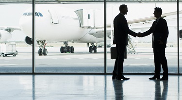 Des hommes d’affaires se serrent la main à la suite d’une rencontre dans un aéroport