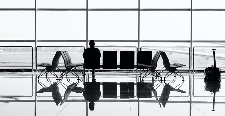 Un passager seul attend son vol dans un aéroport sombre.