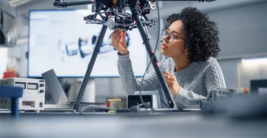 Une femme noire du secteur des technologies inspecte une innovation robotique