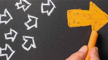 Chalk arrows on a blackboard to show many directions of innovative strategy