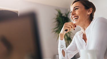 Une entrepreneure souriante à son ordinateur 